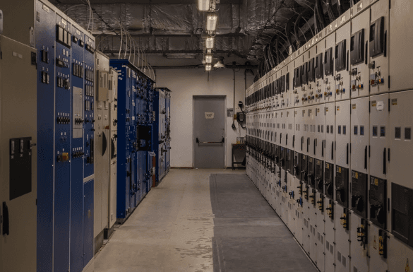 Indoor electrical room with switchgear lineups on both sides of a corridor